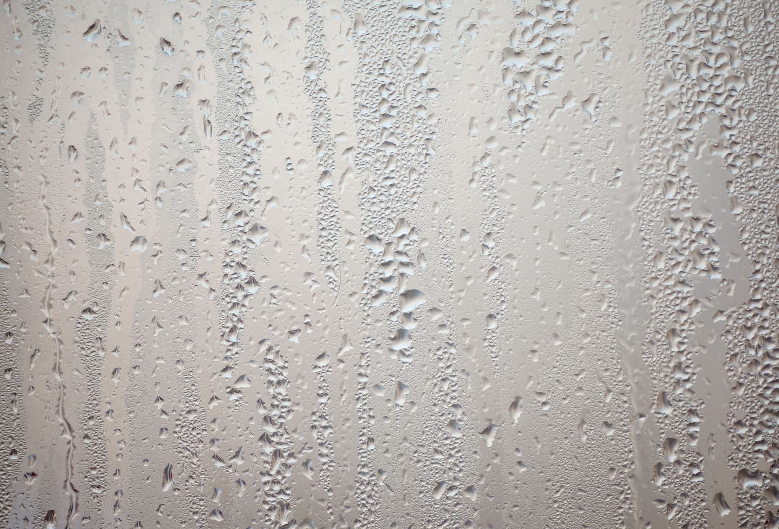 Gotas de condensación resbalando por la cara interior de un vidrio