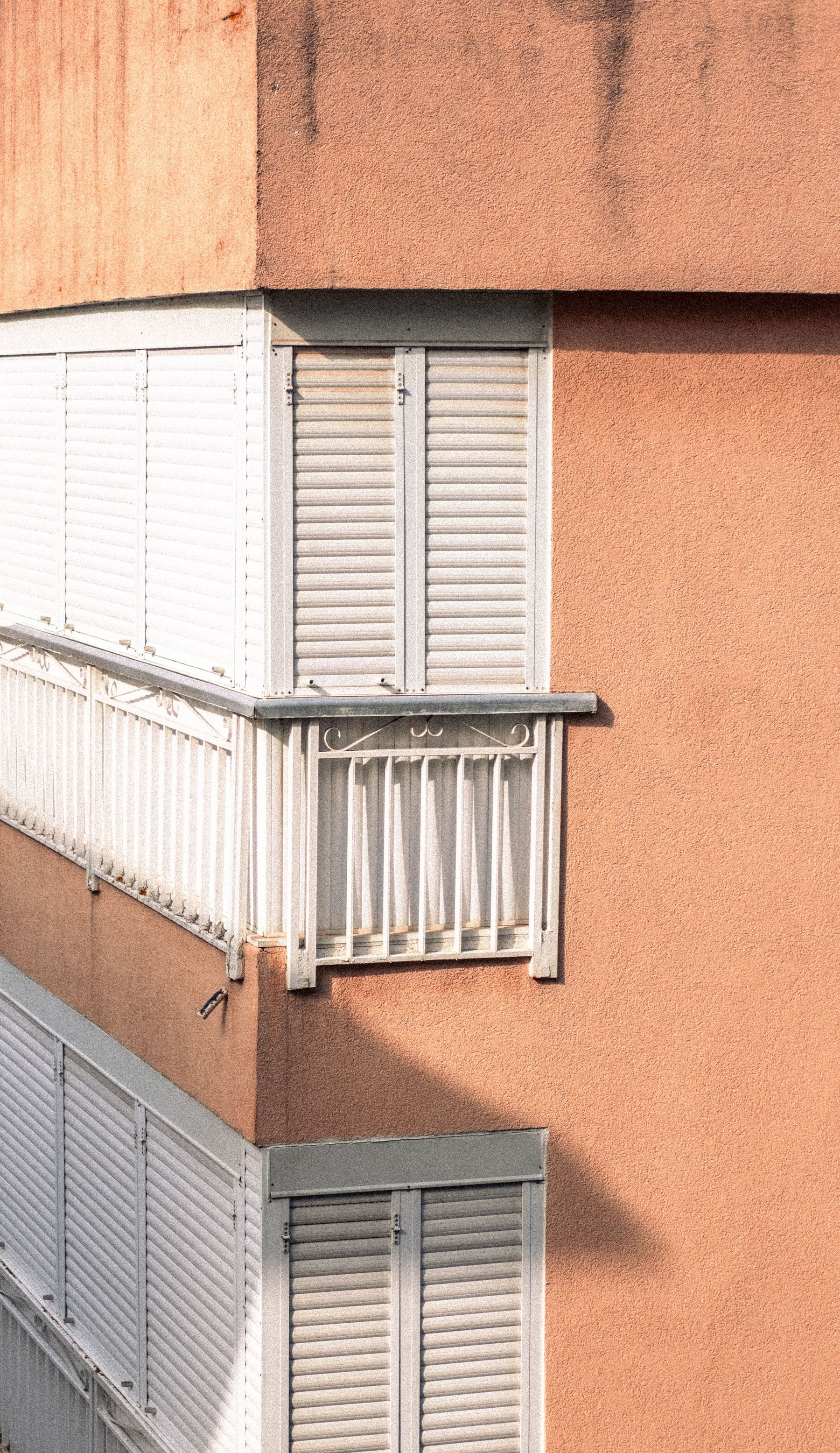 Esquina de un edificio con balcones y persianas enrollables exteriores